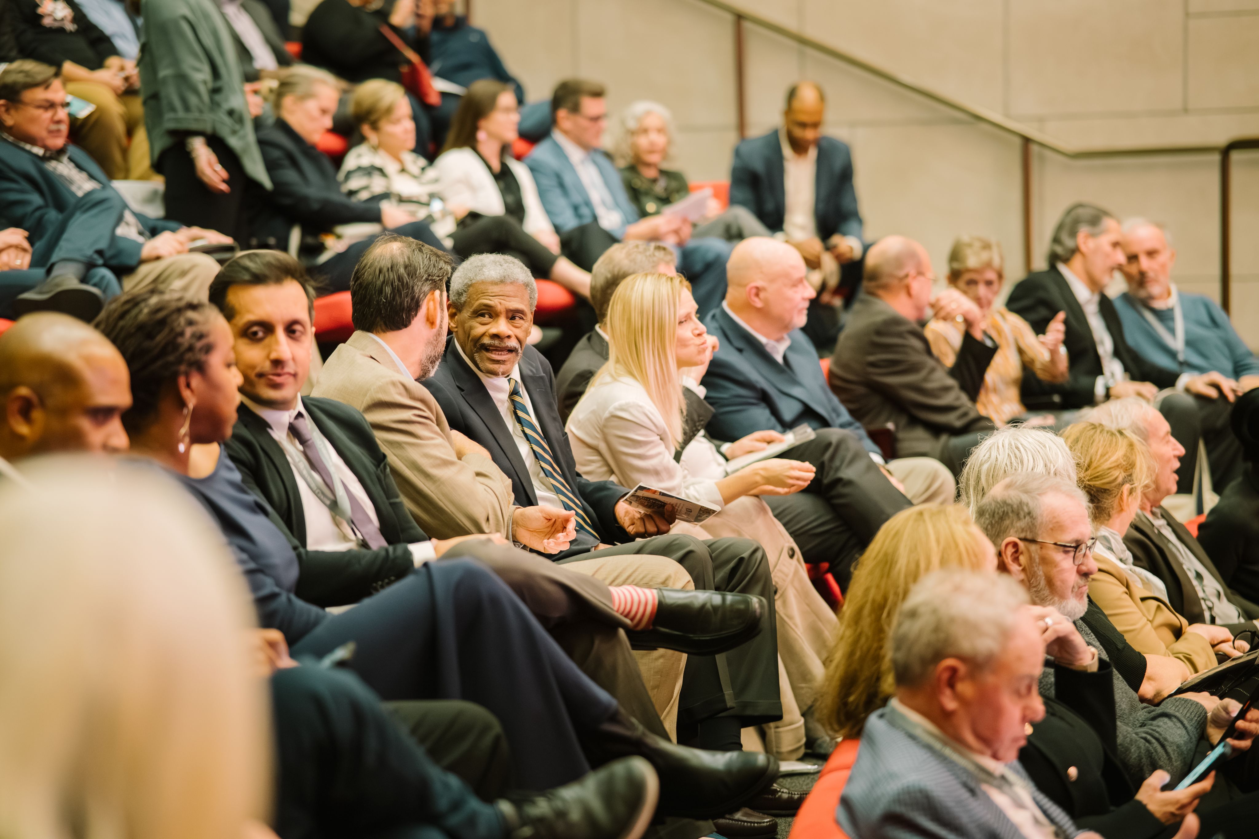 In-person attendees converse with one another and wait patiently for the event to begin