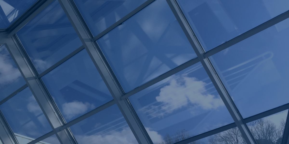 background image shows windows angled toward blue sky with clouds
