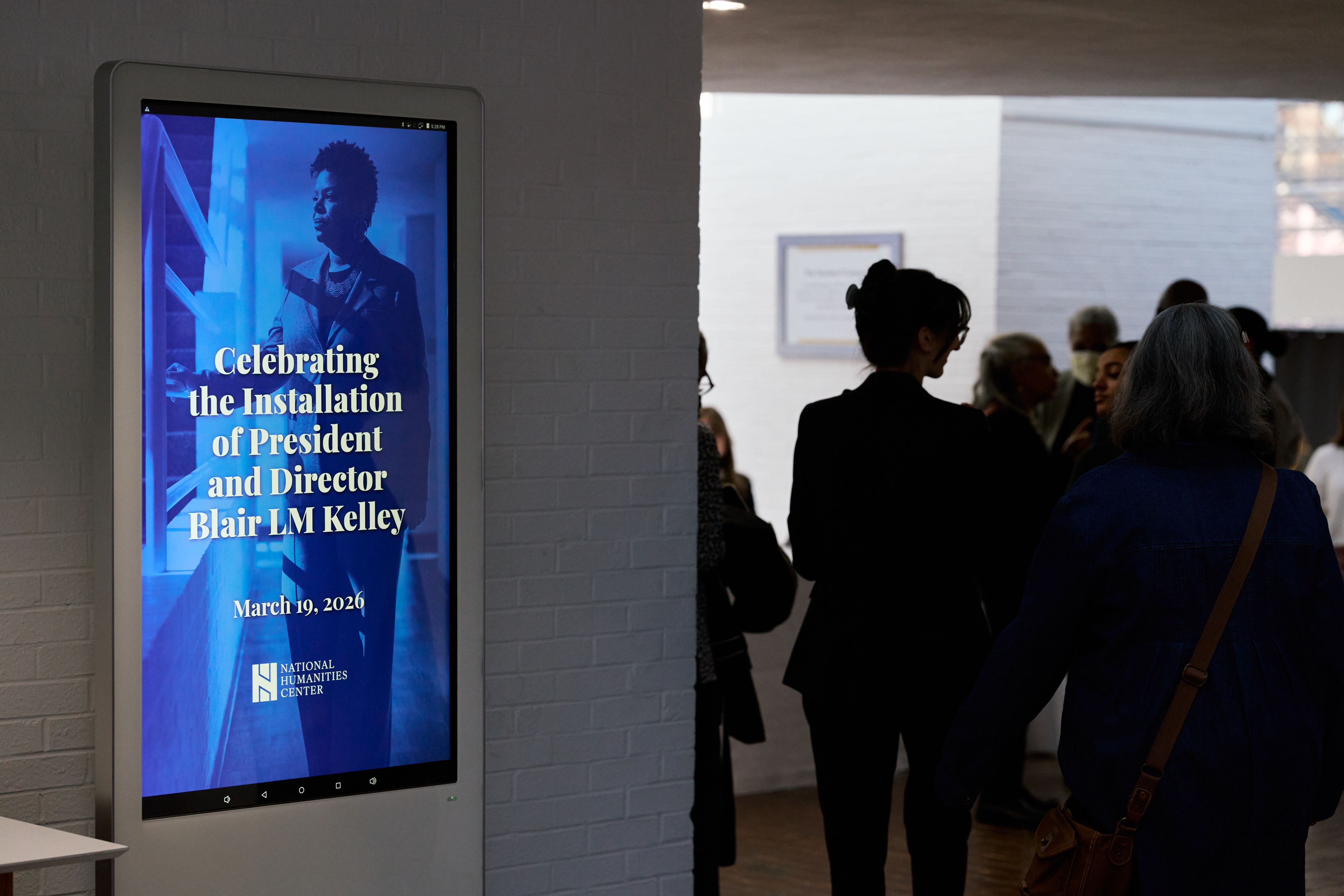 Shows hallway monitor which reads "Celebrating the Installation of President and Director Blair LM Kelley"