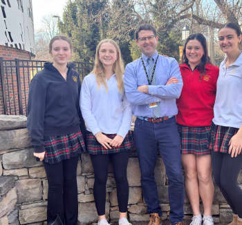 NHC 2024–25 Teacher Advisory Council member Matt Hicks stands with his students